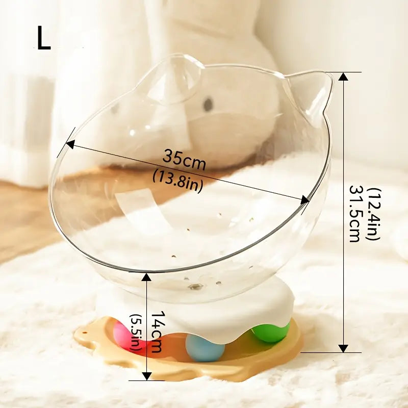An acrylic capsule-shaped cat bowl, with a track ball which is placed on a white rug with measurements