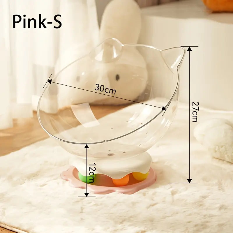A pink acrylic capsule-shaped cat bowl, with a track ball which is placed on a white rug