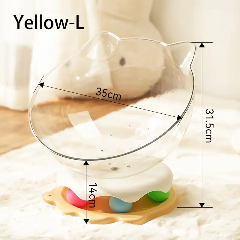 A yellow large acrylic capsule-shaped cat bowl, with a track ball which is placed on a white rug