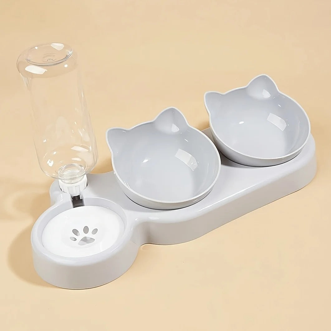 Pet feeding station with two bowls shaped like cats and a water dispenser on a beige background