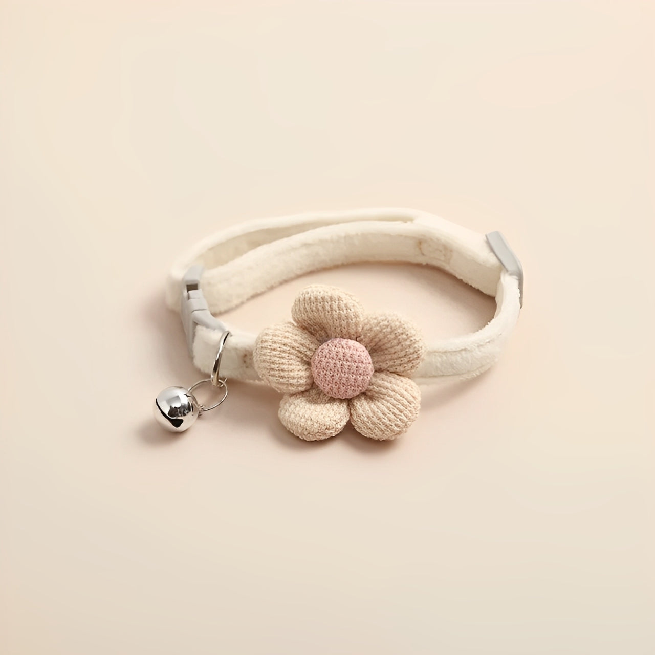 A crochet cat collar in beige with a buckle for adjustability on a beige background