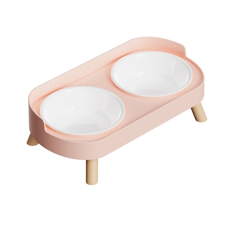 Pink cat feeder with two white bowls on a white background