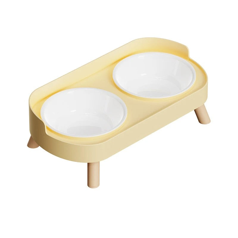 Yellow cat feeder with two white bowls on a white background