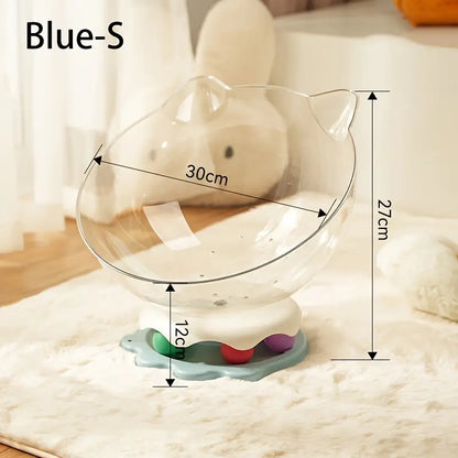 A blue acrylic capsule-shaped cat bowl, with a track ball which is placed on a white rug
