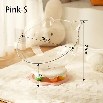 A pink acrylic capsule-shaped cat bowl, with a track ball which is placed on a white rug