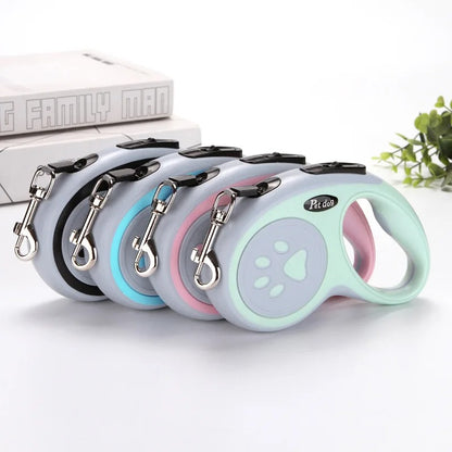 Set of four retractable dog leashes in different colors on a white background.