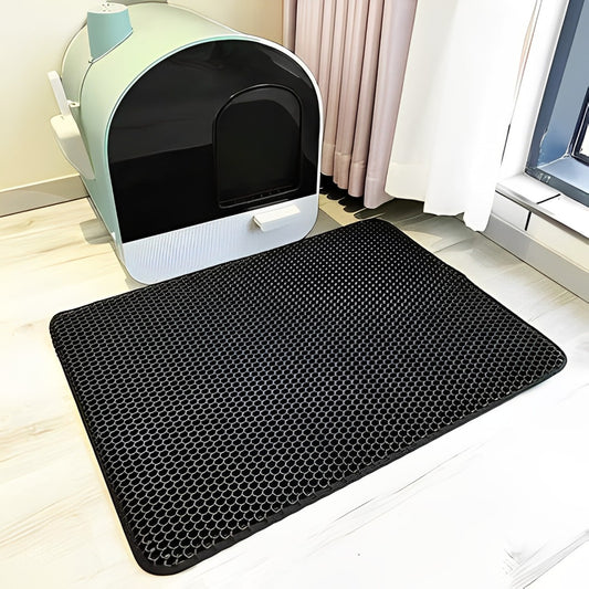 A black non-slip waterproof cat litter mat with a honeycomb texture, shown in front of the cat litter box.