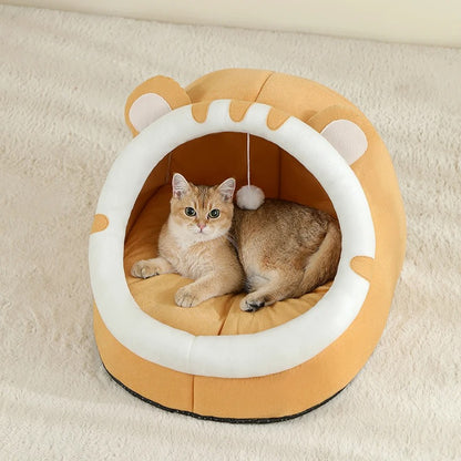 A cat resting inside an orange and white cat nest bed.