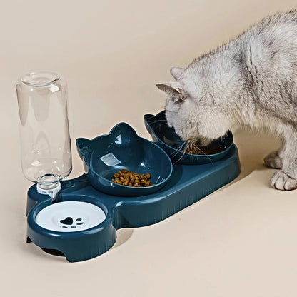 Cat using a blue pet feeder with water bottle and two bowls on a beige surface.