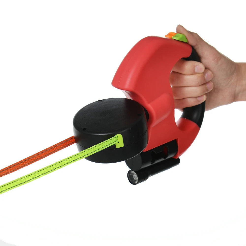 Red and black leash with orange and green rope, held by a hand on a white background