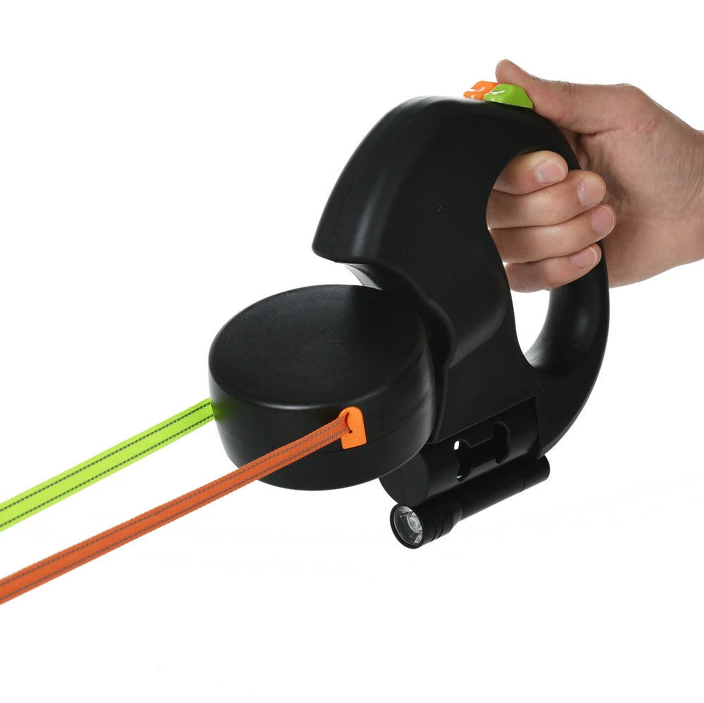 Black leash with green and orange cables being held by a hand on a white background