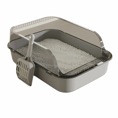 A grey cat litter tray with an open top and a gray scoop, filled with cat litter.