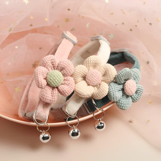 Three handmade crochet cat collars in pink, blue, and beige, each featuring a floral design on a pink background