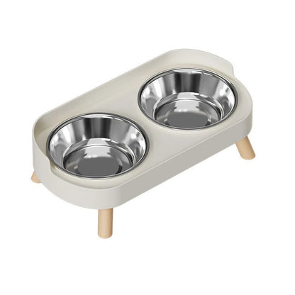 Cat feeding station with two stainless steel bowls on a white background