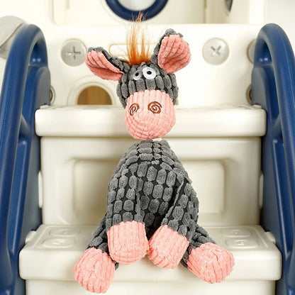 Knitted toy donkey with pink and gray colors on a toy train
