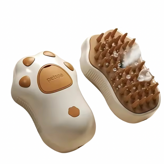 A cat brush with steam featured from two angles, showing the top and bottom of the brush with visible steam vents. The color scheme is primarily beige with a brown and white cat paw design on the handle.