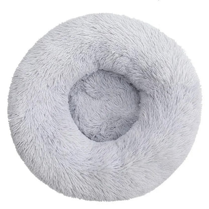A light gray plush round bed with a white background